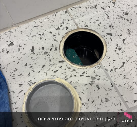פתח ניקוז ברצפה עם מכסה פלסטיק